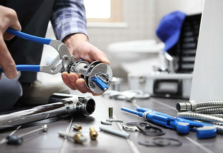 Technician repairing a plumbing fixture with professional tools in Winder