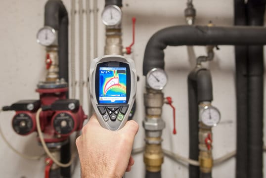 Plumber using a thermal imaging camera to inspect pipes in Winder