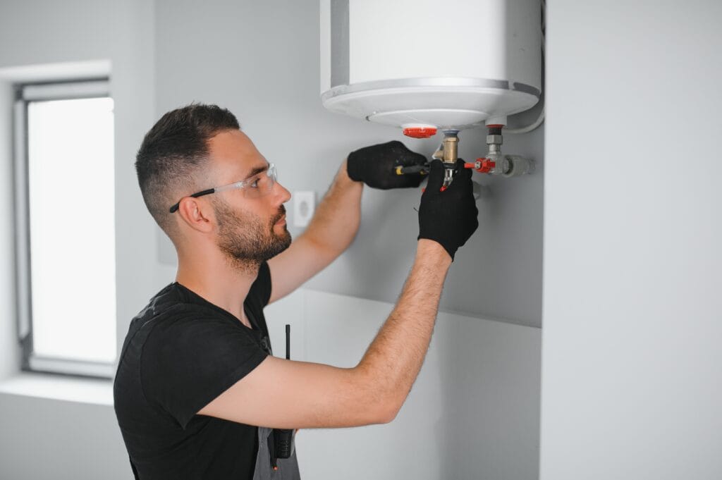 Technician performing water heater maintenance in Winder